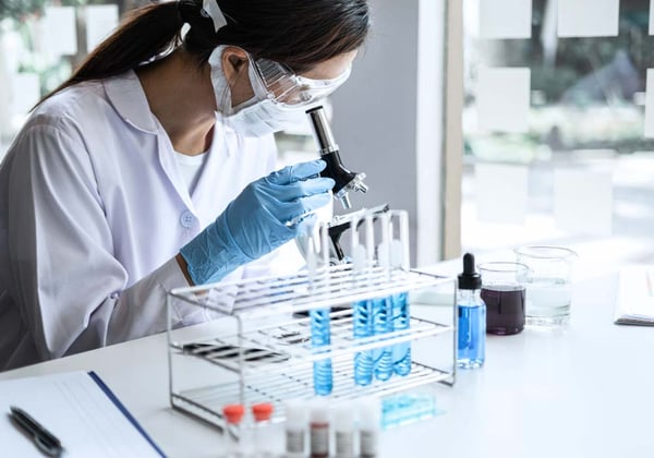 scientist observes liquid solution with a microscope