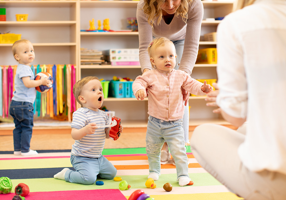 Group of daycare staff with babies in home daycare facility